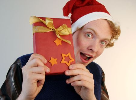 A weird nerd showing an xmas present with eyes wide open.の写真素材