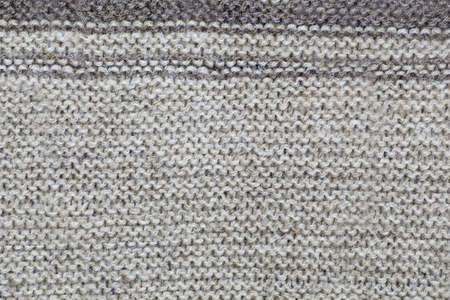 The texture of a knitted brown cloth with stripes. purl and facial loop