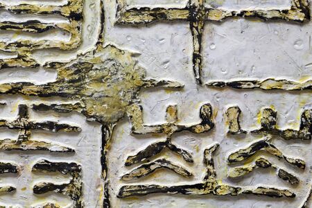 A relief fragment with fantastic ancient text - white and gold. Handwork, ancient art.