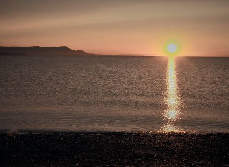 It's summer, we're on vacation and we have a wonderful sunrise. In the distance we see the other shore which is made up of mountains. New Brunswick, Canada; August 19, 2018.の写真素材