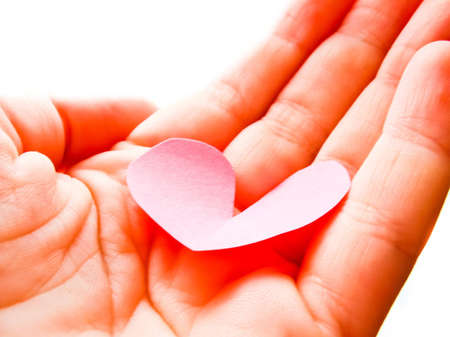 pink paper heart on the handの写真素材
