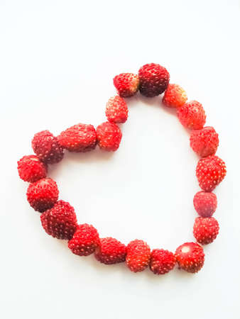 Heart made with strawberries on white backgroundの写真素材