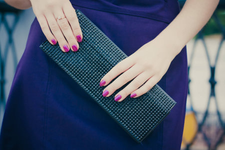 Women holding a black leather bag in her hand