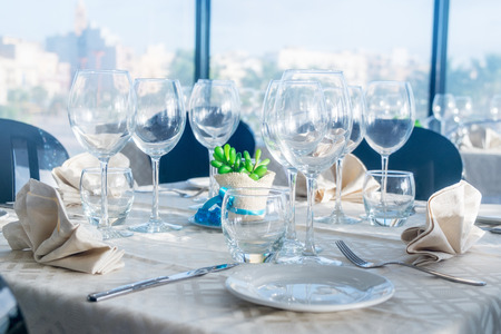 Served tables with empty plates and glasses in luxury restaurant.の写真素材