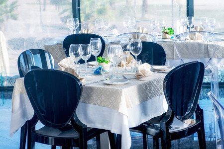 Served tables with empty plates and glasses in luxury restaurant.の写真素材
