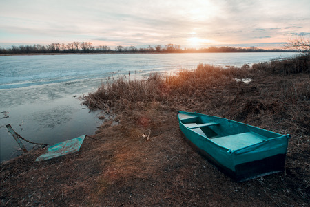 Wooden fishermanâ€™s boat at the bank of Oka River in Russia at sunrise