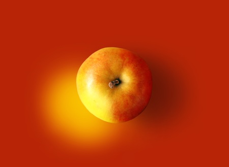 An apple on an abstract red backgroundの写真素材