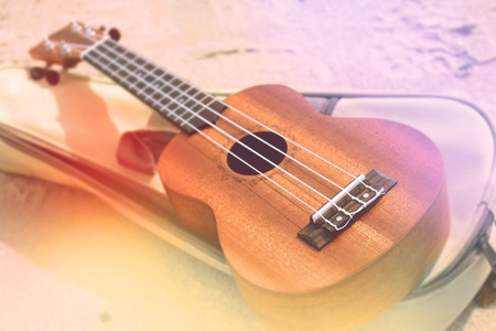 Ukulele guitar on a sand close up