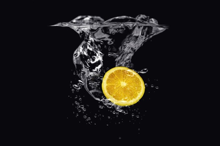 Lemon in water isolated on black