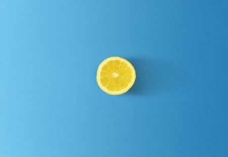 Lemon isolated on blue background, minimalism