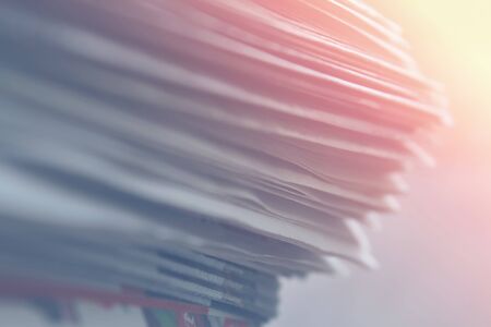 Stack of newspapers close up background, soft light