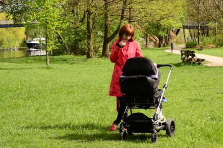 young mother with a baby carriage in the park