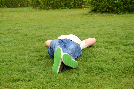 young man lying on the grassの写真素材
