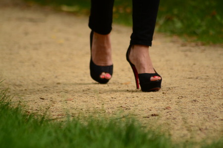  Woman in black sandals and platform heels walking on the footpath