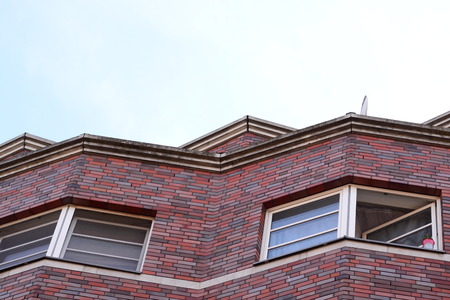 windows in the top floor of a residential brick buildingの写真素材