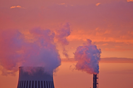 pipe with steam over the city at dawn