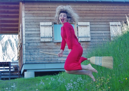 shaggy woman in red long dress on a broomの写真素材