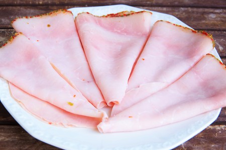 slices of ham on a white plateの写真素材