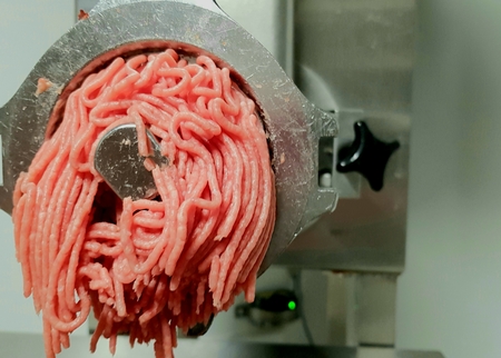 Meat twisted in a large meat grinderの写真素材