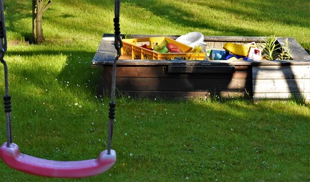 Swing on a rope and wooden sandbox with toys