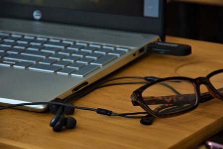 Keypad, glasses and headphones on a wooden tableの写真素材