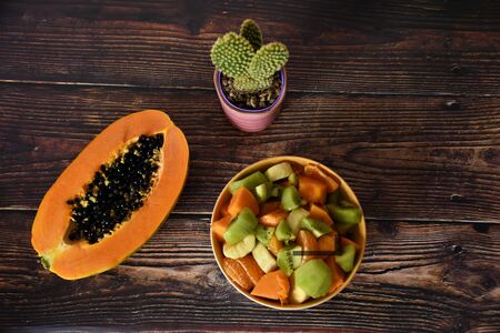Tropical fruit salad and green cactus in a pot