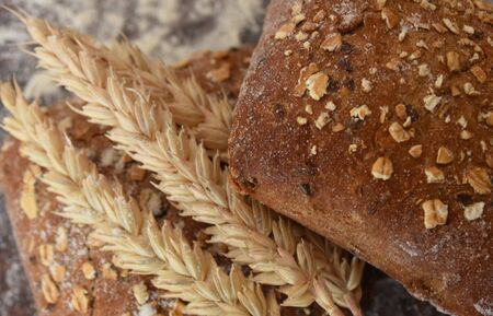 Baked rye buns with cereal flakes and ears of wheat