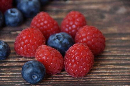Ripe raspberries and blueberries closeupの写真素材
