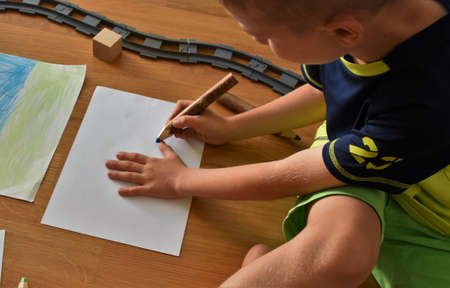 boy sits on the floor and draws picturesの写真素材