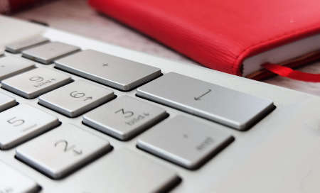 red notebook and keyboard from laptop