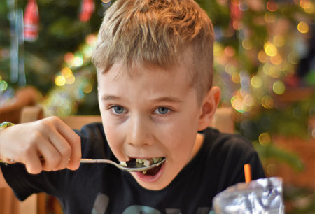 boy eating salad with a big spoon