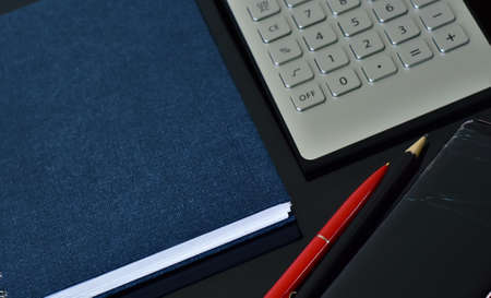 notebook, calculator and pen with pencil on the tableの写真素材