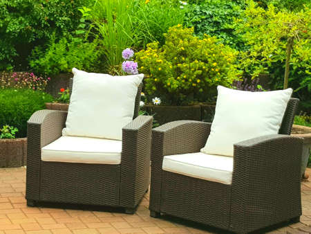 two armchairs with cushions stand in the courtyard near the flowersの写真素材