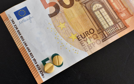 fifty euro and pills on black background
