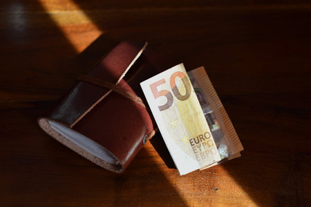 50 euro and leather bound notebook on wooden backgroundの写真素材