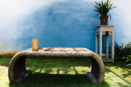 Wooden table and chair in the garden with blue wall background.の写真素材