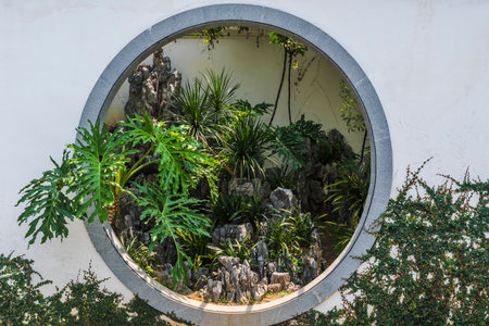 Beautiful view through a round window of a green plant garden.の写真素材