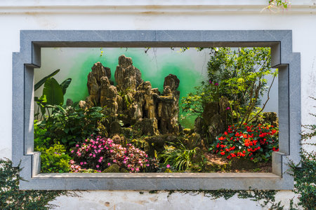 Exotic flower garden in a window frame, beautiful flowers in the gardenの写真素材