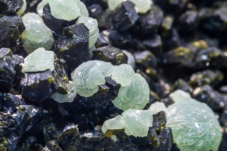 Emerald agate on the black volcanic rock. Natural background.の写真素材