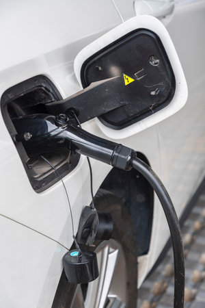 Charging an electric car with a plug. Close-up.
