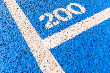 White line on the blue asphalt of the stadium with the inscription 2020の写真素材