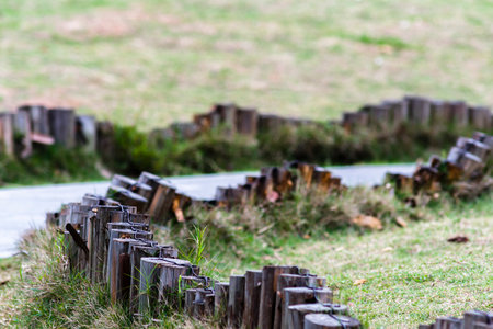 Wooden fence in the park with green grass and blurred background.の写真素材
