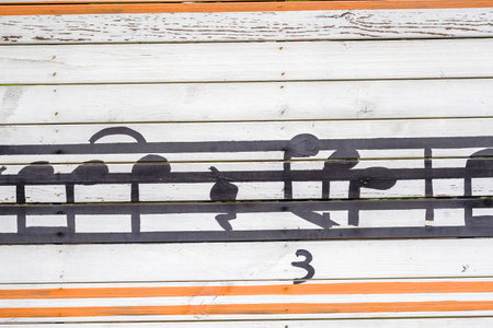 Musical notes on the wall of an old wooden building. Abstract backgroundの写真素材