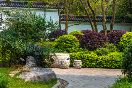 Stone walkway in the garden with green trees and shrubs.の写真素材