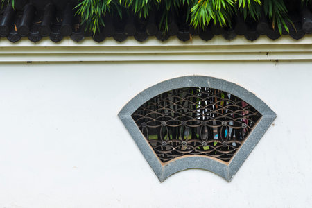 Decorative window in Thai style on white wall background, Thailand.