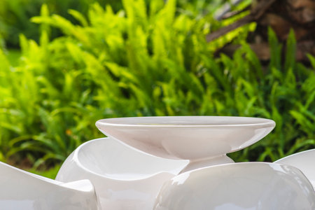 White tableware in the garden with fresh green grass and flowers.の写真素材