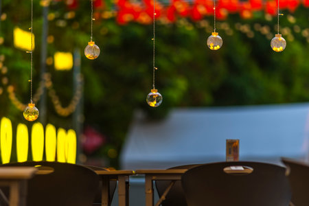 Outdoor cafe with light bulbs in the evening. Selective focus.の写真素材