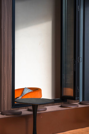 Orange chair and orange pillow on the black table in cafe, stock photoの写真素材