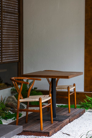 Wooden table and chair in the garden with white wall background.の写真素材