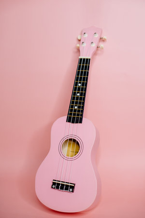 pink ukulele on a pink background